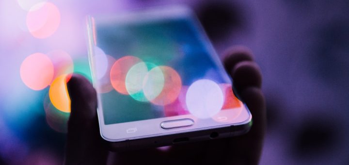 Person holding a smartphone to withdraw money via mobile money